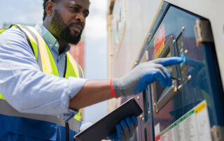 Worker checking the temperature settings of a refrigerated container